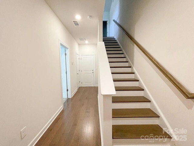 staircase with wood finished floors and baseboards
