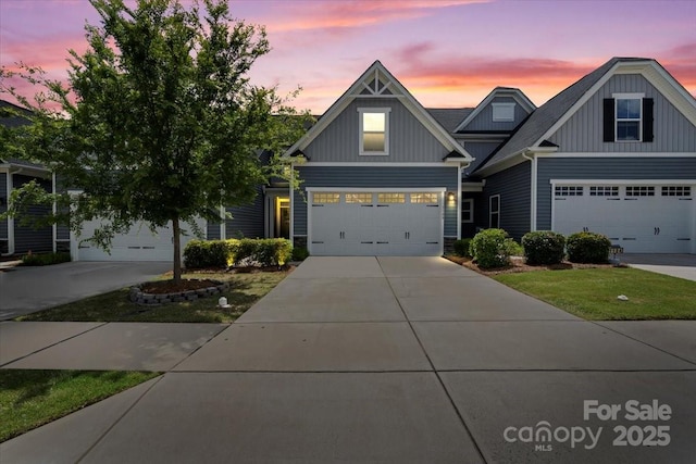 craftsman inspired home with board and batten siding, driveway, an attached garage, and stone siding