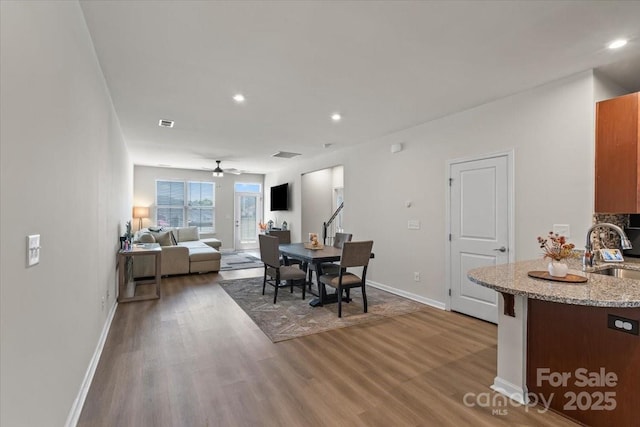 dining area featuring wood finished floors, baseboards, ceiling fan, and recessed lighting