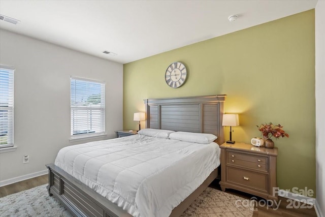 bedroom with dark wood-type flooring and baseboards