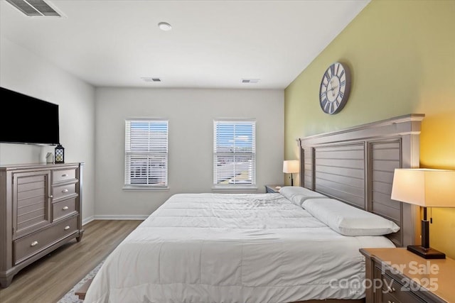 bedroom featuring wood finished floors and baseboards