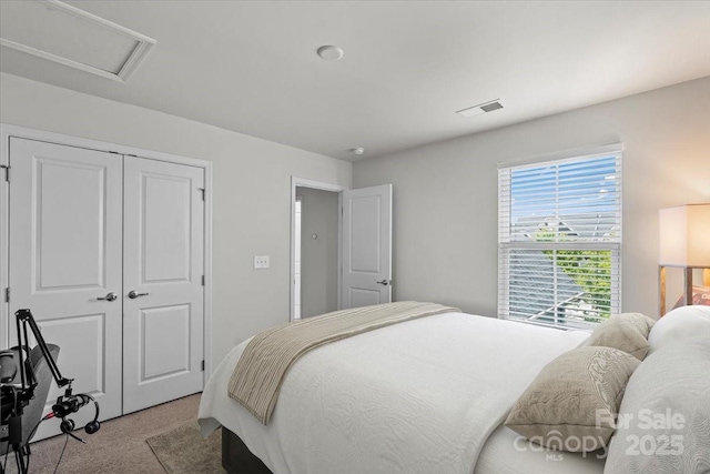 bedroom featuring light carpet, a closet, and attic access