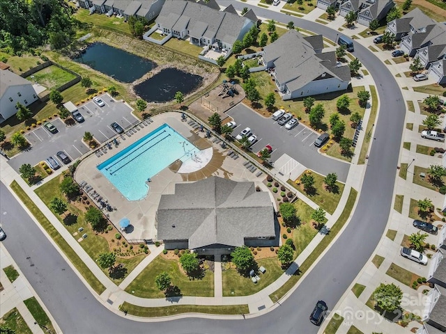 aerial overview of property's location featuring a pool, a nearby body of water, and nearby suburban area
