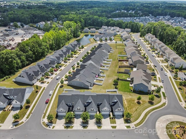 view of property location with nearby suburban area and a forest