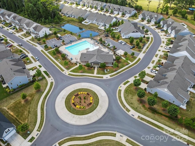 view of property location featuring a pool, nearby suburban area, and a nearby body of water