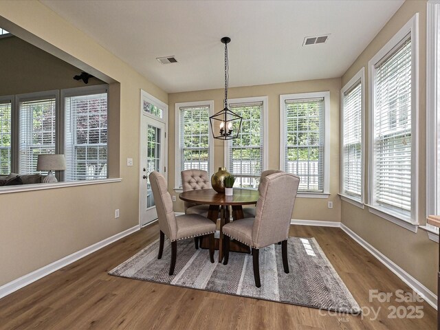dining space featuring wood finished floors, baseboards, and plenty of natural light