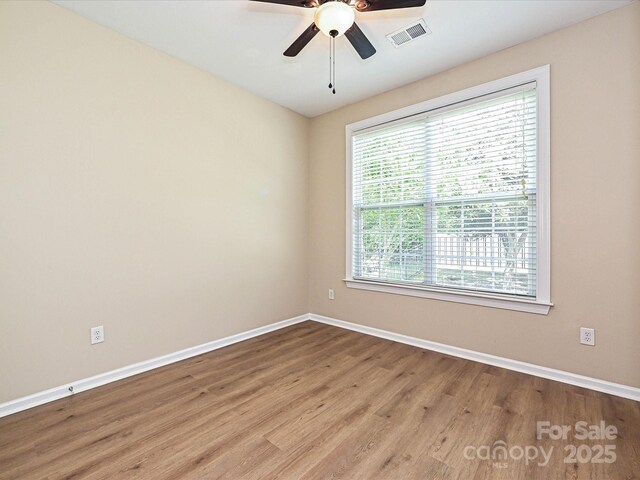 empty room featuring baseboards, wood finished floors, and ceiling fan