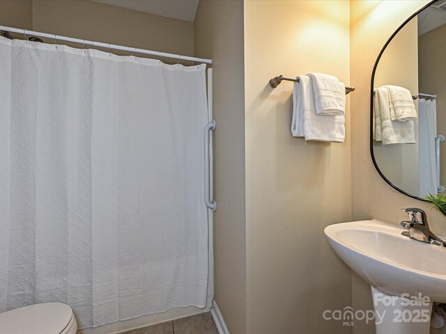 full bath with tile patterned flooring, toilet, a sink, and a shower with shower curtain