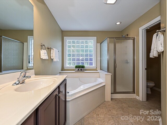 bathroom featuring a stall shower, vanity, a garden tub, toilet, and recessed lighting