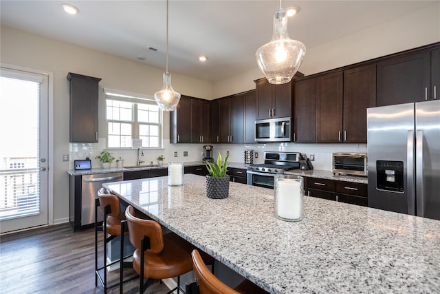 9521 Ainslie Downs St, Charlotte, NC 28273 - kitchen with appliances with stainless steel finishes, a sink, light stone countertops, dark brown cabinets, and recessed lighting