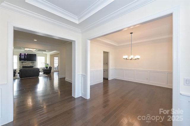 809 Brown Creek Dr, Matthews, NC 28104 - unfurnished dining area featuring dark wood finished floors, a chandelier, crown molding, a wainscoted wall, and a decorative wall