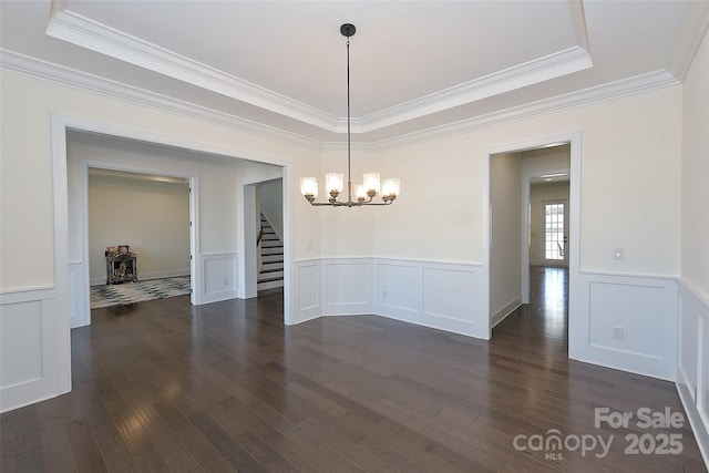 809 Brown Creek Dr, Matthews, NC 28104 - unfurnished dining area with a chandelier, stairway, a raised ceiling, crown molding, and dark wood-type flooring