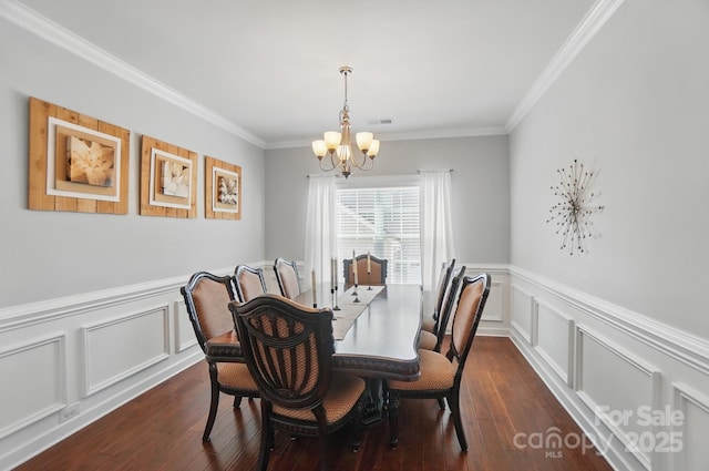 16831 Alydar Commons Ln, Charlotte, NC 28278 - dining space featuring a chandelier, dark wood-style flooring, crown molding, a decorative wall, and a wainscoted wall