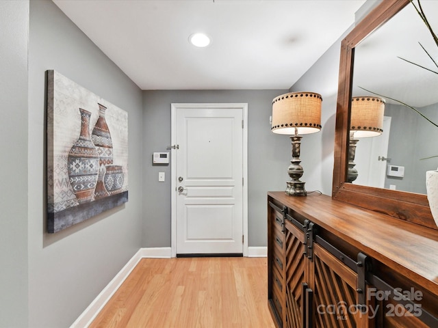 entryway featuring baseboards, light wood finished floors, and recessed lighting