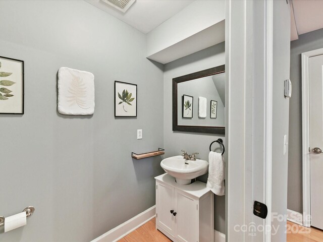 bathroom featuring vanity, baseboards, and wood finished floors