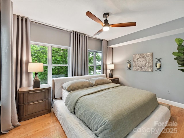 bedroom featuring light wood-style flooring, ceiling fan, and baseboards