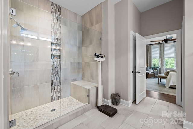 ensuite bathroom with a walk in shower, baseboards, ceiling fan, and tile patterned flooring