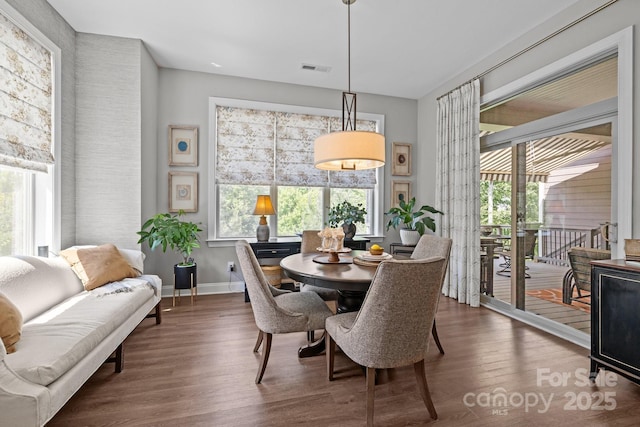 dining space featuring wood finished floors, plenty of natural light, and baseboards