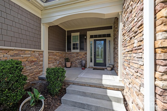 property entrance featuring a porch and stone siding