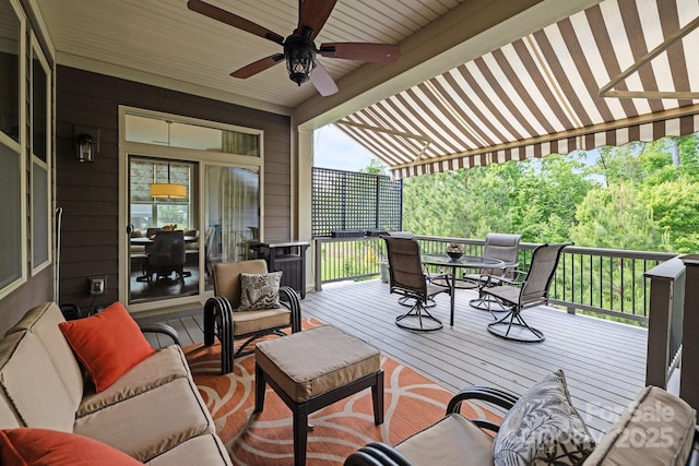 wooden terrace featuring outdoor dining area and a ceiling fan