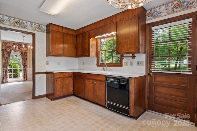 1940 12th St NE, Hickory, NC 28601 - kitchen featuring a chandelier, black dishwasher, wallpapered walls, a sink, and light countertops