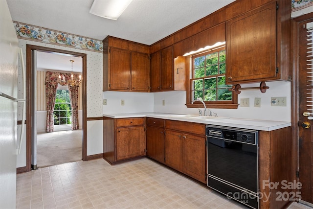 1940 12th St NE, Hickory, NC 28601 - kitchen featuring black dishwasher, wallpapered walls, light countertops, a chandelier, and brown cabinetry