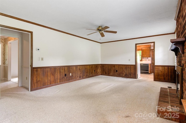 1940 12th St NE, Hickory, NC 28601 - unfurnished living room with a wainscoted wall, ceiling fan, a fireplace, light colored carpet, and wooden walls