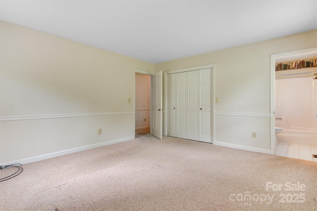 1940 12th St NE, Hickory, NC 28601 - unfurnished bedroom featuring carpet, baseboards, connected bathroom, and a closet