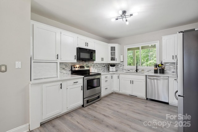 4516 Kiser Island Rd Unit 1, Terrell, NC 28682 - kitchen with stainless steel appliances, a sink, tasteful backsplash, white cabinets, and light countertops