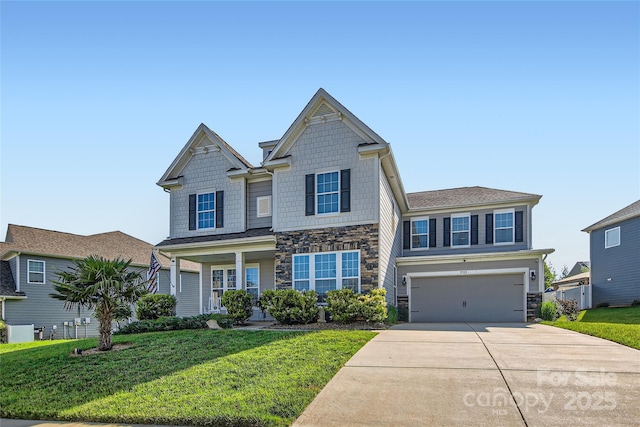 craftsman house featuring stone siding, driveway, a front yard, and an attached garage