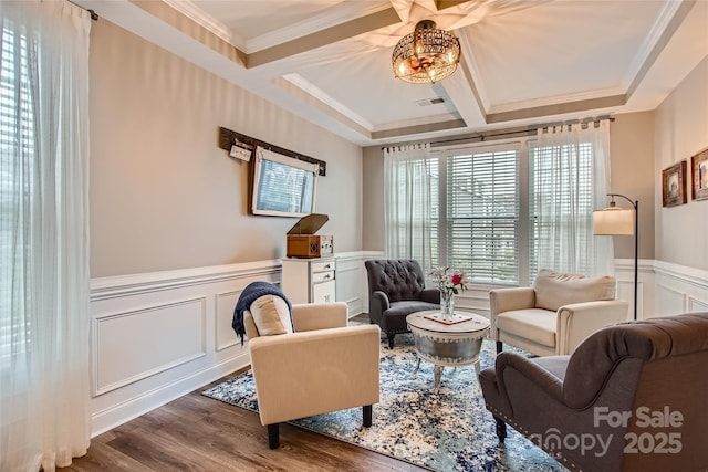 living area with coffered ceiling, wood finished floors, a decorative wall, beam ceiling, and a wainscoted wall