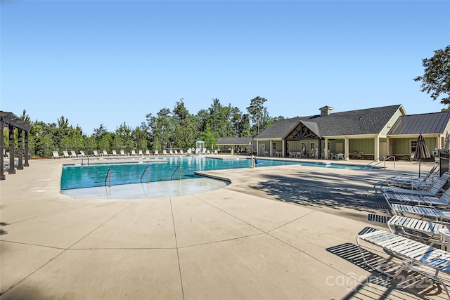 community pool with fence and a patio