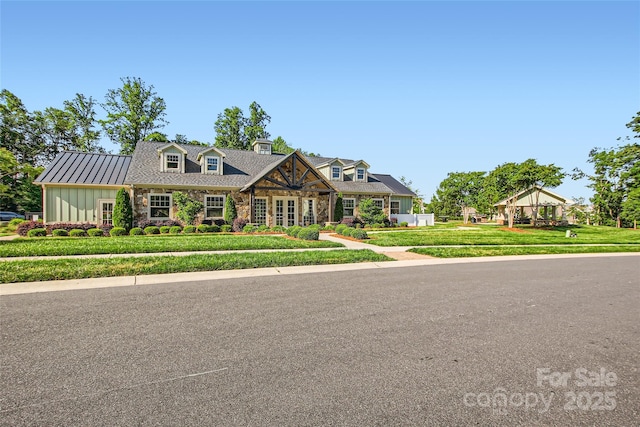 view of front of home with stone siding, a front lawn, and board and batten siding
