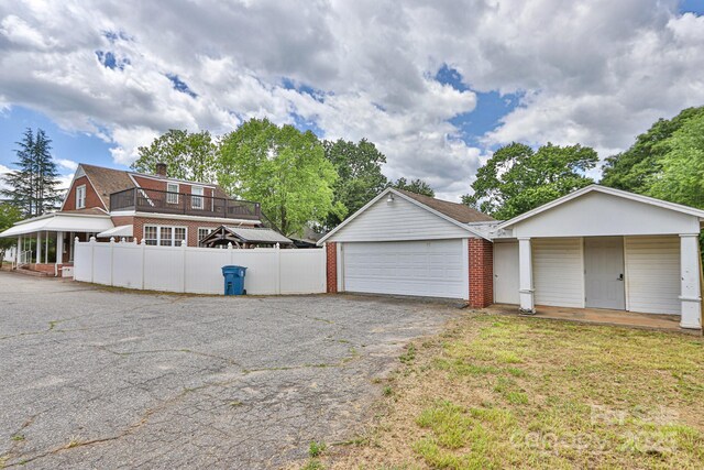 garage with fence and asphalt driveway