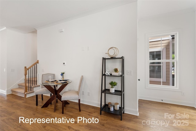 dining room with wood finished floors, stairway, and baseboards