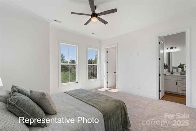 bedroom with carpet flooring, baseboards, ensuite bath, a sink, and a ceiling fan