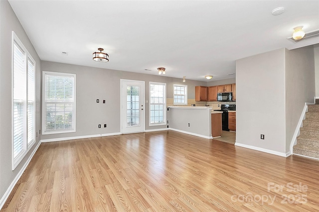 unfurnished living room featuring light wood-style floors and baseboards