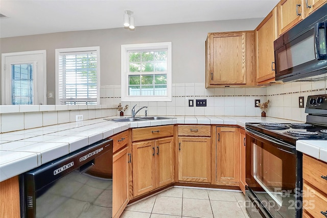 kitchen featuring black appliances, a sink, and tasteful backsplash