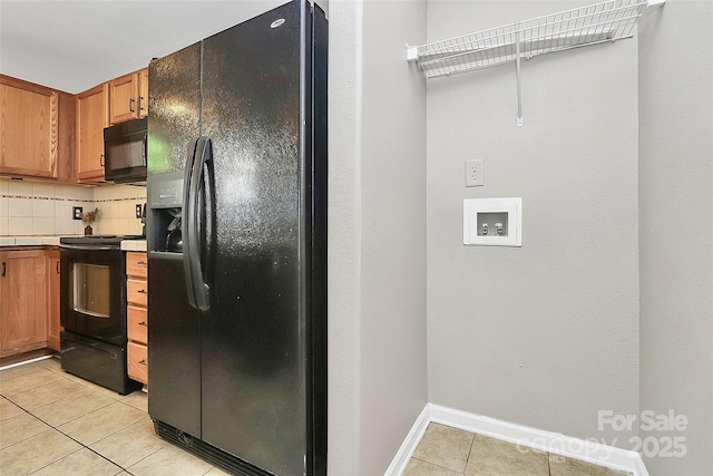 kitchen featuring black appliances, light tile patterned flooring, tasteful backsplash, and brown cabinetry