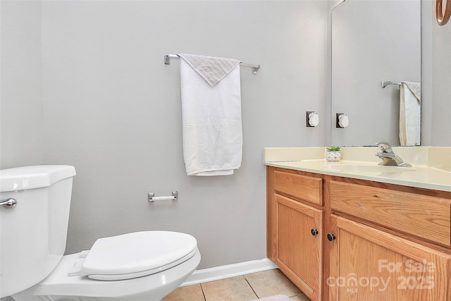 bathroom featuring toilet, tile patterned flooring, vanity, and baseboards