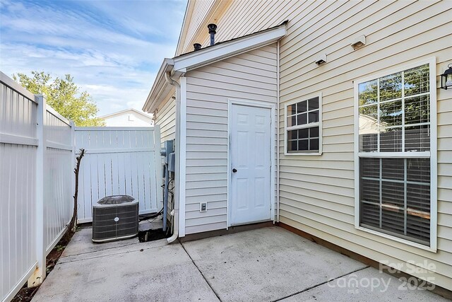 view of patio with cooling unit and fence
