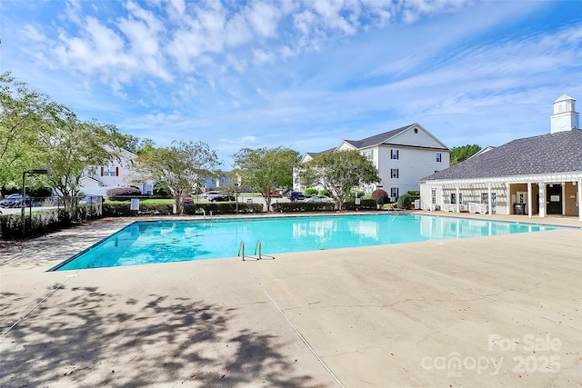 community pool with a patio and a residential view