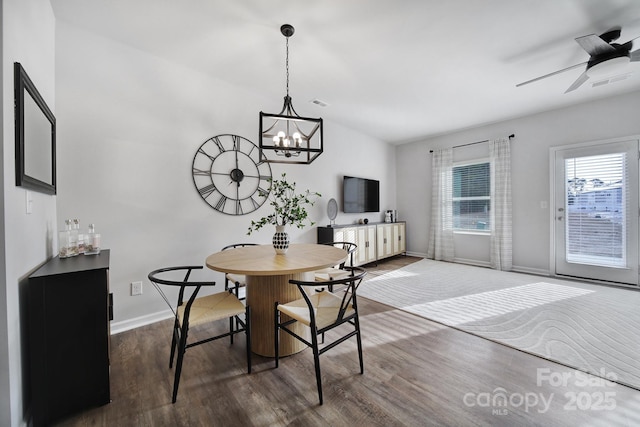 dining room featuring dark wood-type flooring, lofted ceiling, baseboards, a chandelier, and ceiling fan