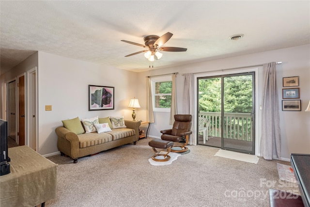 carpeted living area featuring ceiling fan and baseboards