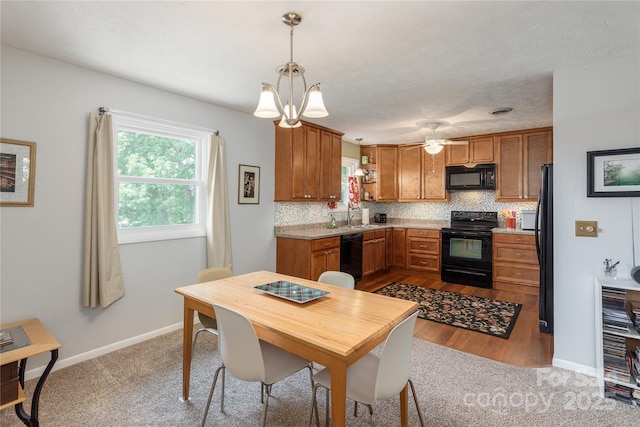 kitchen featuring black appliances, brown cabinets, backsplash, and light countertops