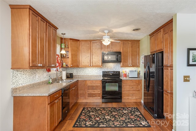 kitchen featuring black appliances, a sink, dark wood-style flooring, a ceiling fan, and a textured ceiling