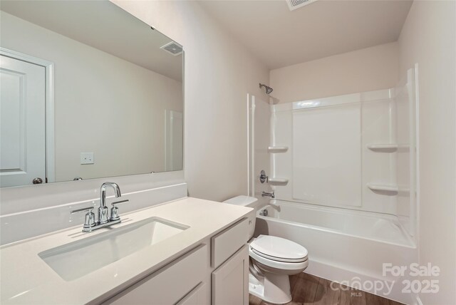 full bathroom with toilet, wood finished floors, vanity, and bathing tub / shower combination