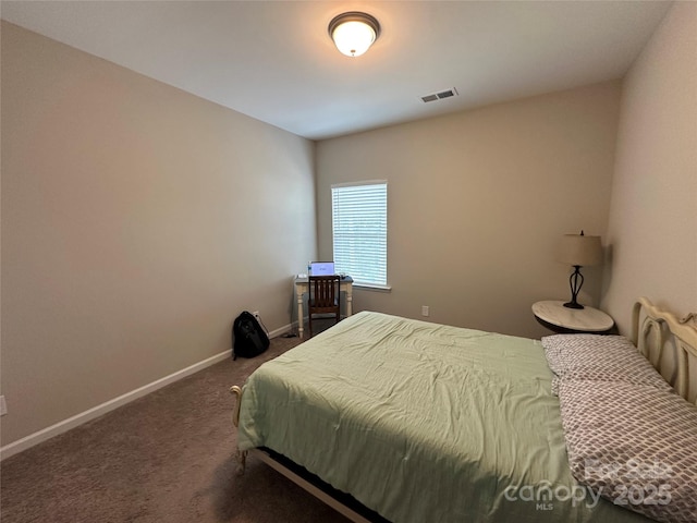 bedroom featuring dark carpet and baseboards