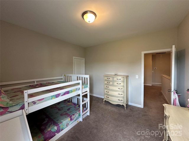 bedroom featuring dark carpet and baseboards