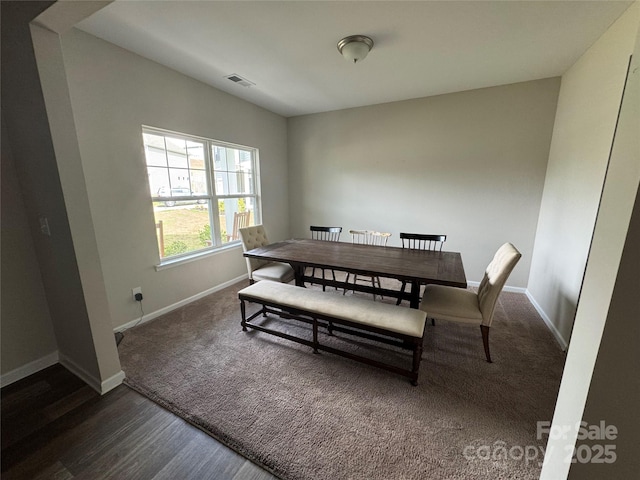dining space featuring baseboards, wood finished floors, and carpet floors